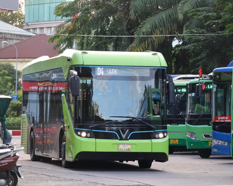 A bright green electric bus parked at a station.